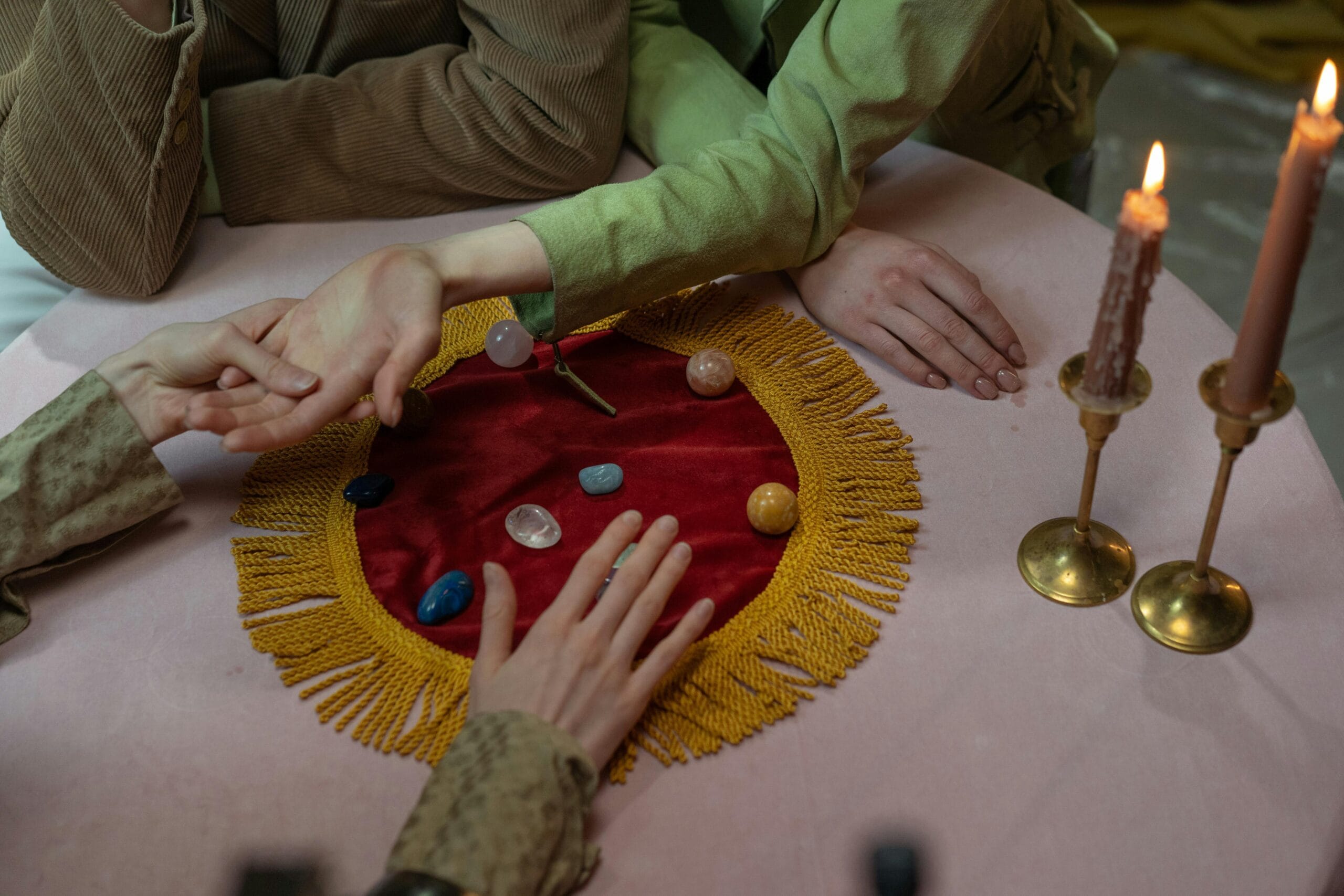 Close-up of a fortune-telling session with crystals, candles, and palm reading.